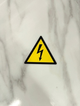 Tabliczka ostrzegawcza: Napięcie elektryczne | W012 | Zgodna z DIN EN ISO 7010 | laminat | 70 mm